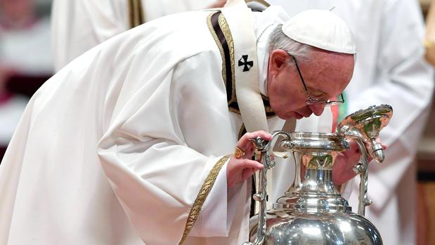 El papa Francisco observa un ánfora que contiene el óleo santo mientras oficia la misa Crismal de Jueves Santo en la Basílica de San Pedro del Vaticano