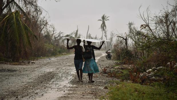 Imagen de archivo de dos mujeres protegiéndose de la lluvia en Haití, en 2016