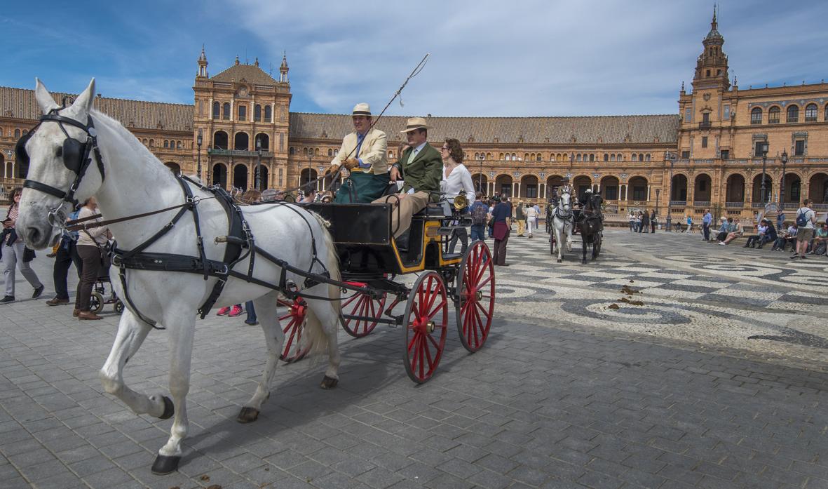 Un desfile de coches de caballos por el casco histórico de una ciudad