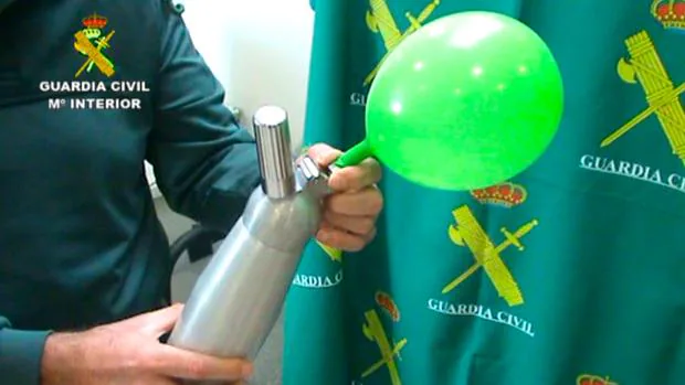 Agente de la Guardia Civil hinchando un globo con Óxido nitroso
