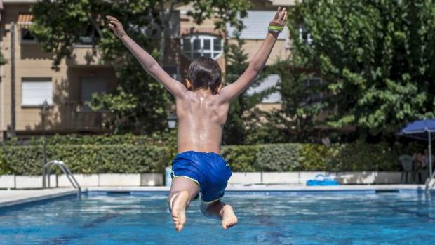 Un niño se zambulle en el agua en una piscina