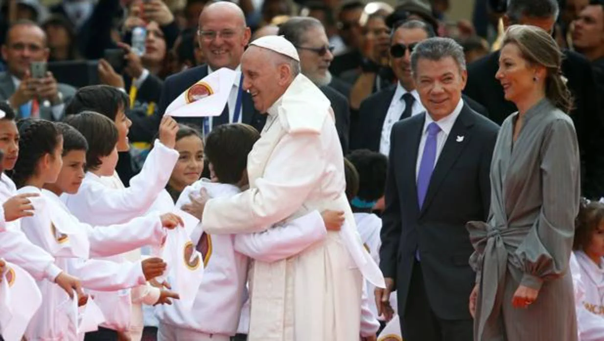Un niño saluda al Papa con un abrazo en presencia de Juan Manuel Santos, presidente del país, y su esposa