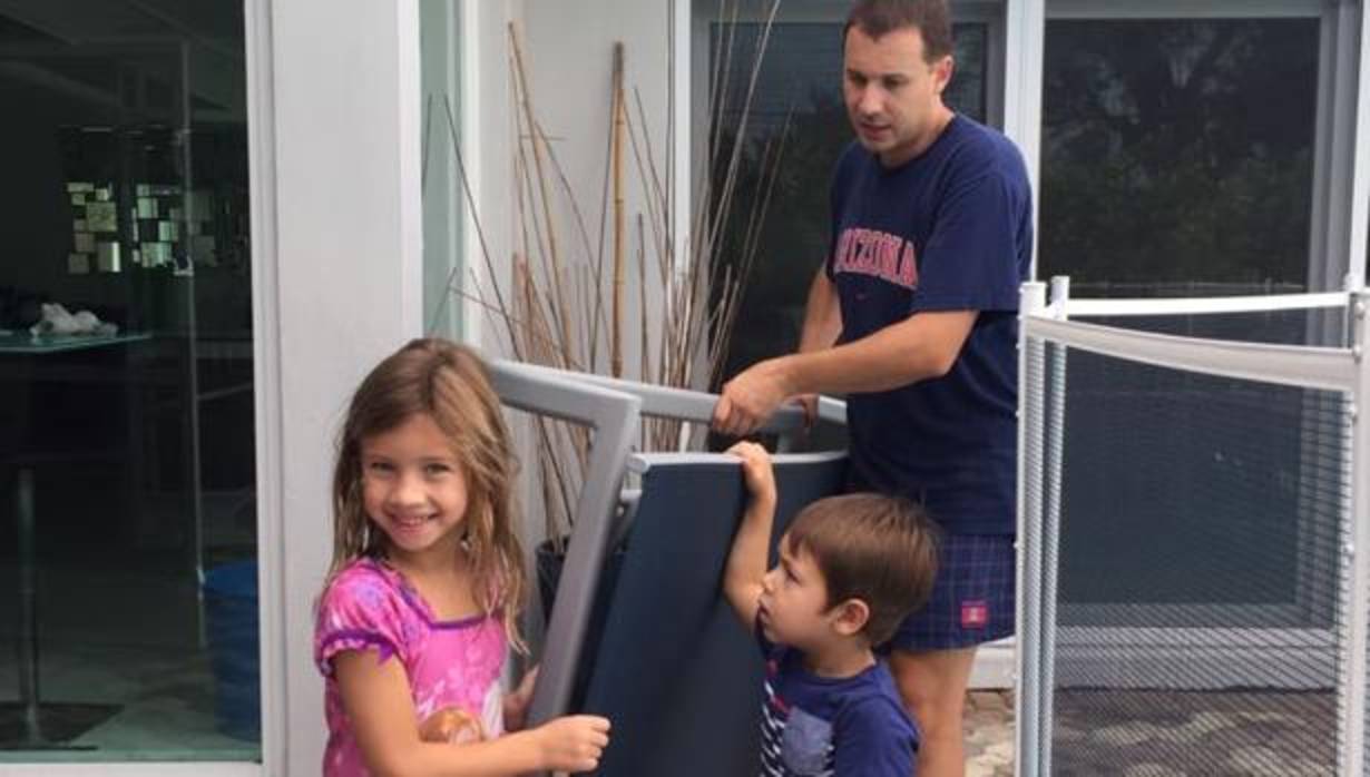 Tasio Suárez, ayudado por dos de sus hijos, retira el mobiliario de la terraza ante la llegada del huracán Irma