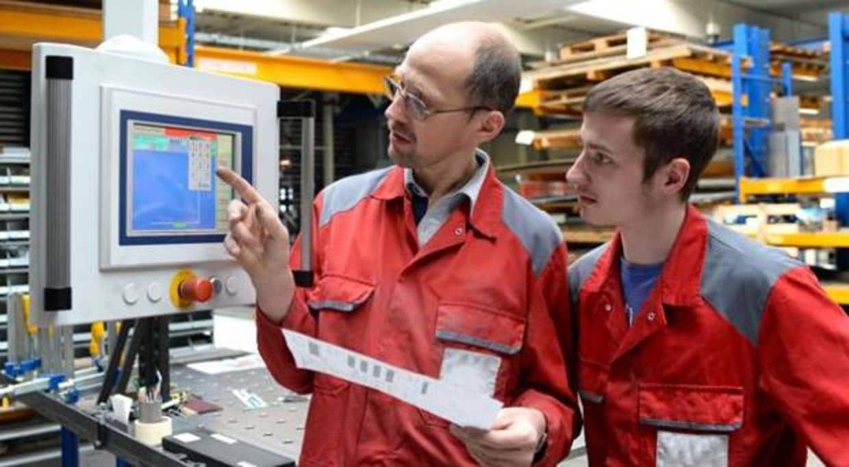 Un aprendiz alemán atiende a las explicaciones de su superior en una empresa metalúrigca