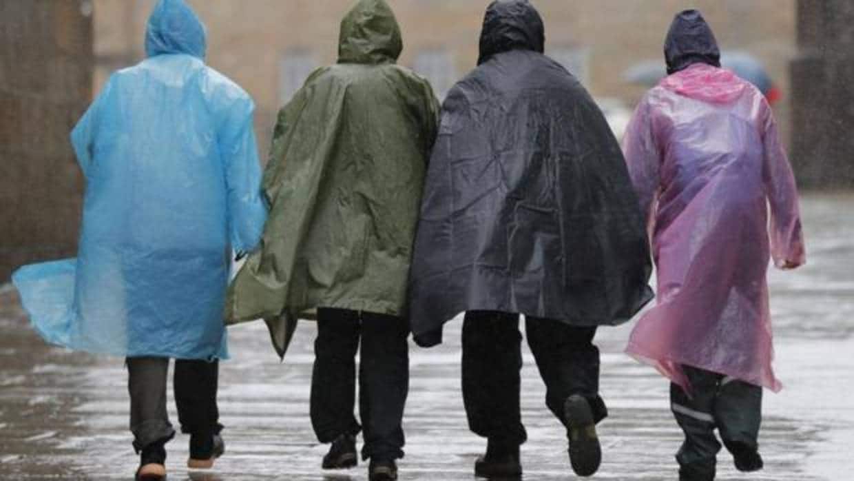 Varias personas caminan bajo la lluvia en la plaza del Obradoiro, en Santiago de Compostela