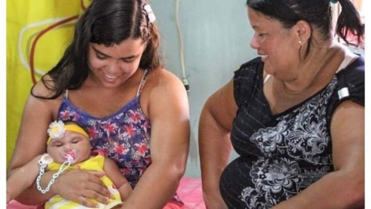 Duda, en brazos de Cleane da Silva, la nuera de Miriam Pereira (a la derecha), que tiene 20 años y ayuda a cuidar al bebé