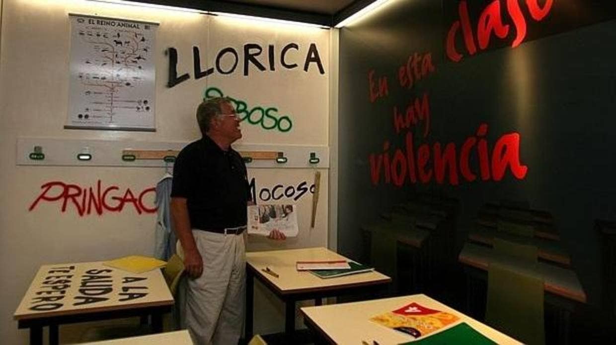 Un profesor contempla las pintadas en un aula en un caso de acoso escolar a un alumno
