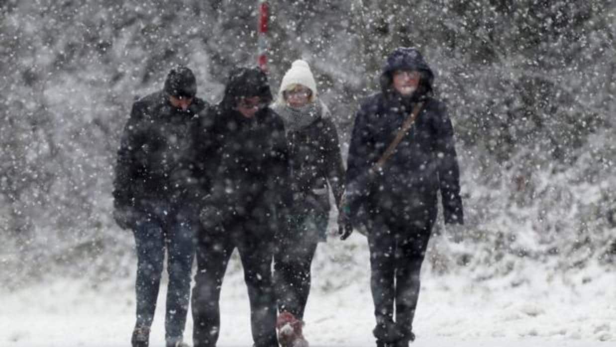 Un grupo de personas, andando bajo la nieve en España