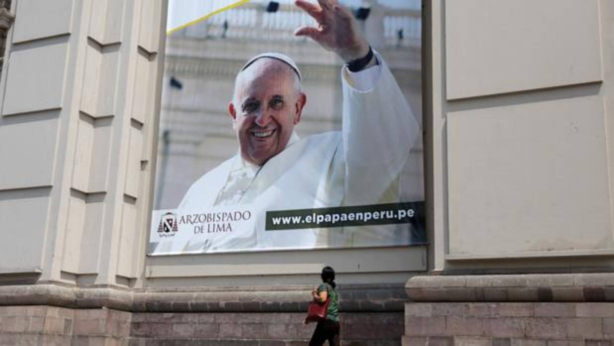 Una persona camina frente a la Catedral de Lima, donde ya se anuncia la próxima llegada del Papa