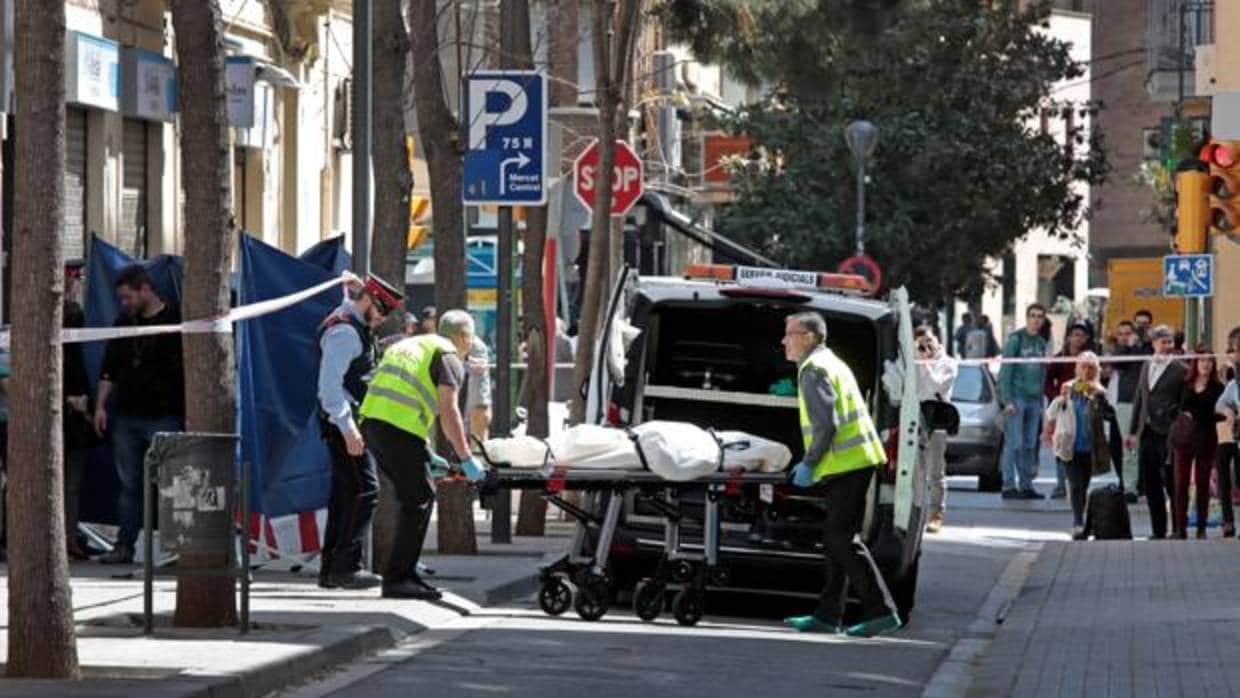 Agentes del servicio funerario transportan el cadáver de la mujer asesinada en Sabadell