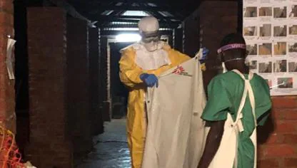 Luis Encinas, español que combate el ébola en República Democrática del Congo ayuda a un trabajador sanitario con las medidas de protección contra la enfermedad