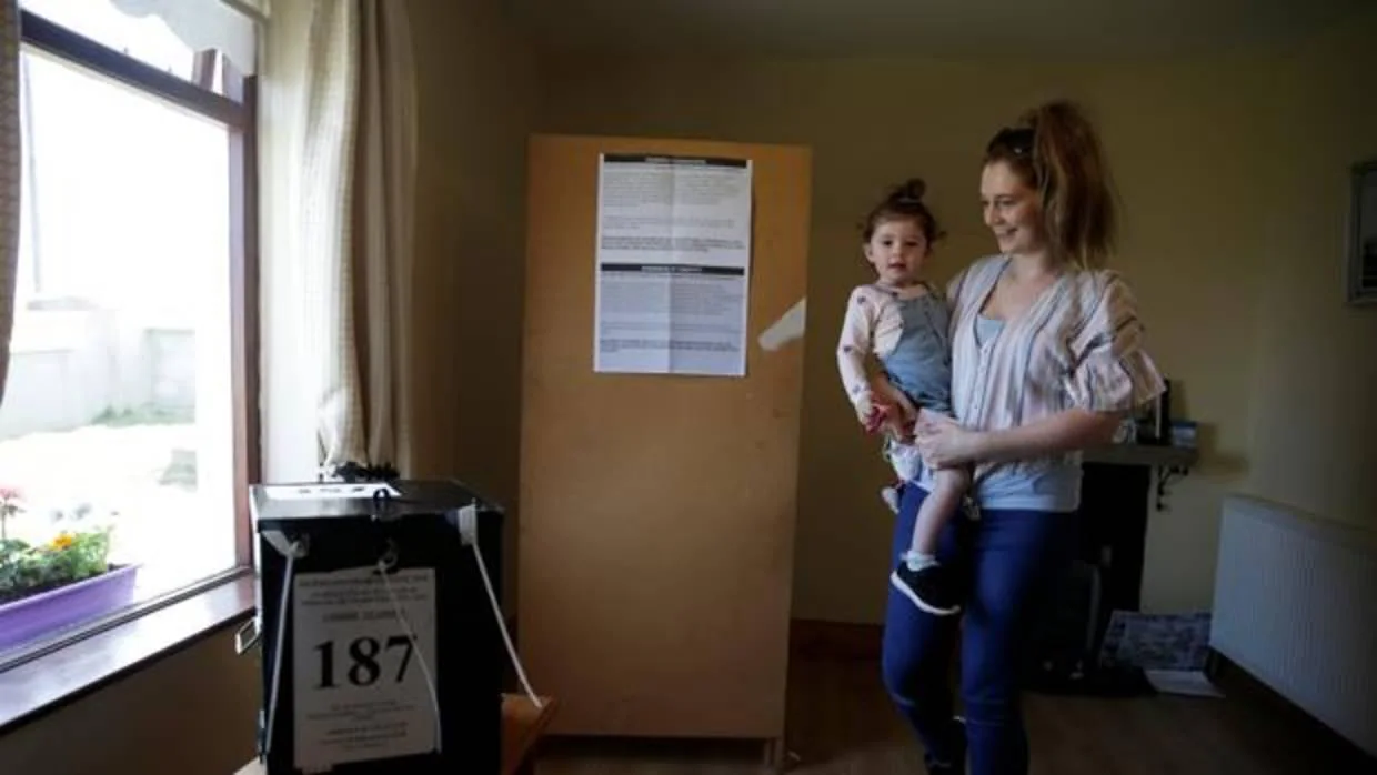 Una mujer con su hijo mientras vota en el referendum de Irlanda referente al aborto