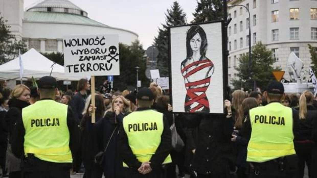 Una mujer sostiene un cartel en el que se lee «Libertad de elección no terror» durante la manifestación en contra de la prohibición del aborto