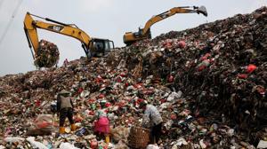 Varias personas buscan deshechos plásticos en una montaña de basura