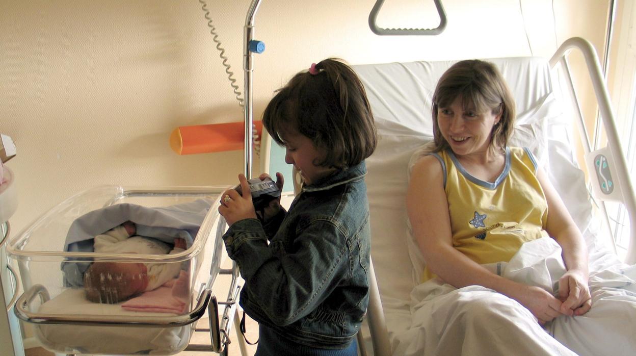 Imagen de archivo en la que aparece un bebé junto a su madre y su hermana en unhospital francés