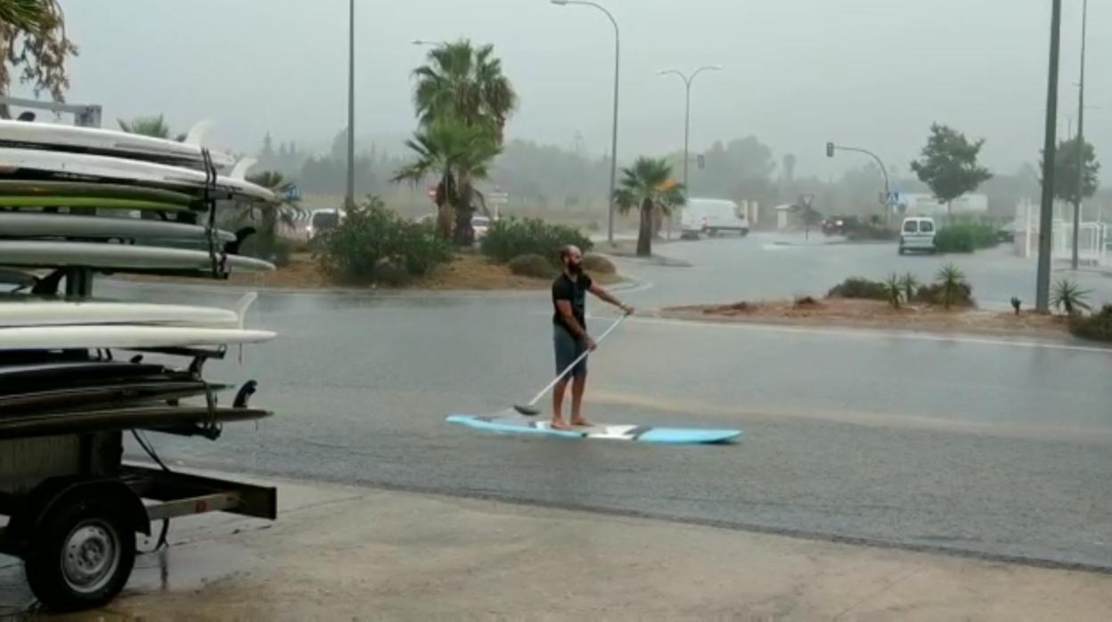 Un joven navega con una tabla de paddle surf en medio de una calle de Ibiza