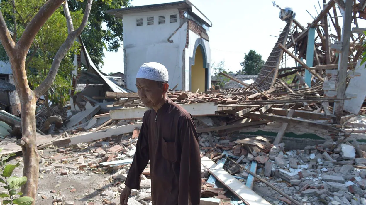 Un hombre pasa por delante de varios edificios derribados por un terremoto en Lombok