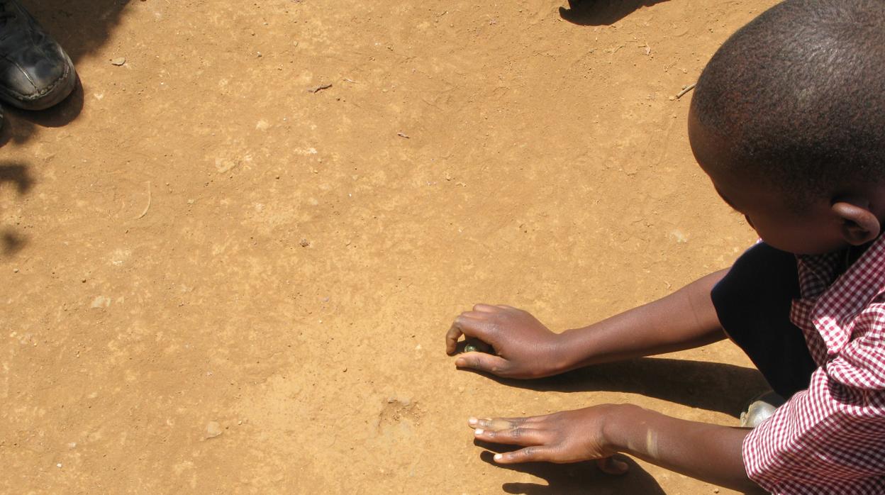 Imagen de archivo de un niño jugando a las canicas en un colegio de Nairobi