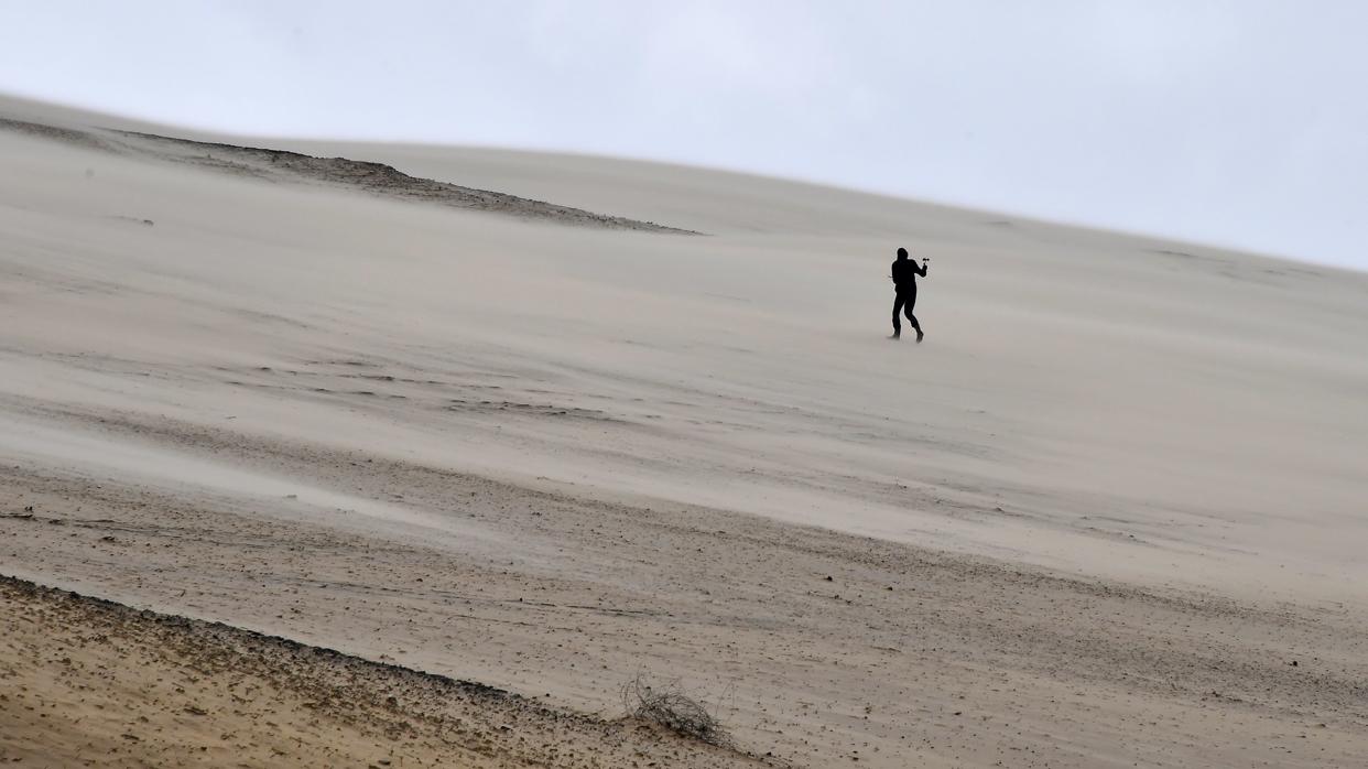 Una persona mide la velocidad del viento en el Pilat Dune cerca de Arcachon, suroeste de Francia, también asediada por la tormenta Gabriel