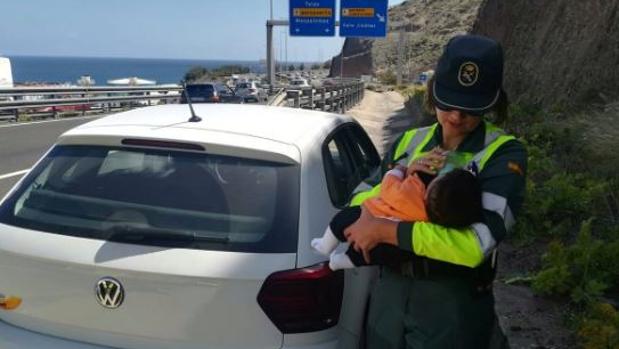 Una guardia civil cuida de un bebé cuyo padre había sufrido un amago de infarto al volante