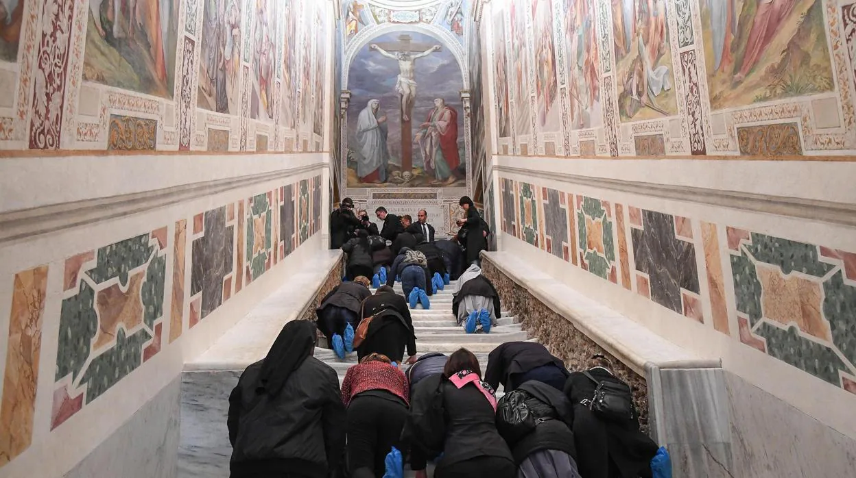 Varias personas recorren de rodillas la Escalera Santa durante su apertura extraordinaria, este jueves en la Basílica de San Juan de Letrán, Roma (Italia)