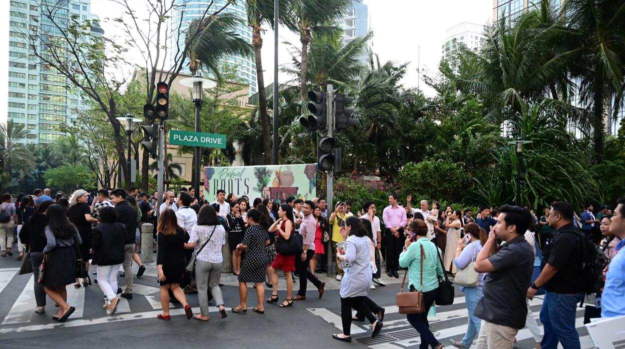 Filipinos son evacuados en el distrito financiero de Macati debido a un terremoto, este lunes en Manila