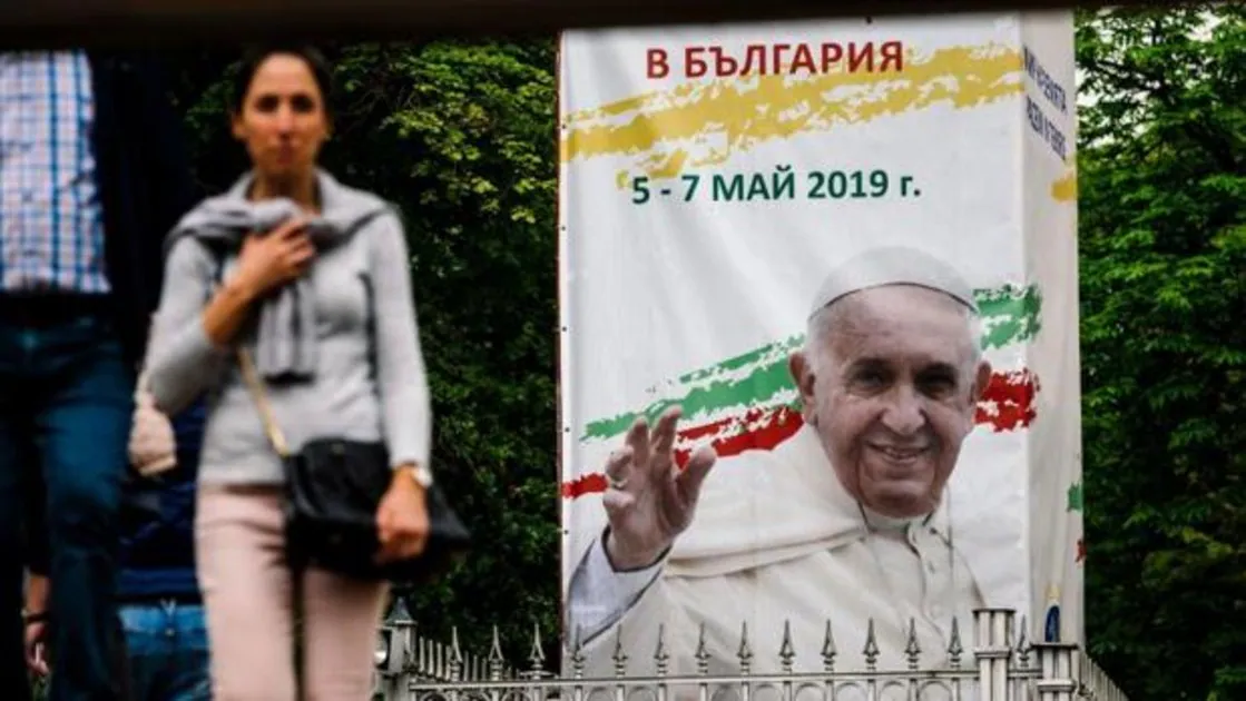 Una mujer camina junto a un cartel del Papa en Sofía, Bulgaria