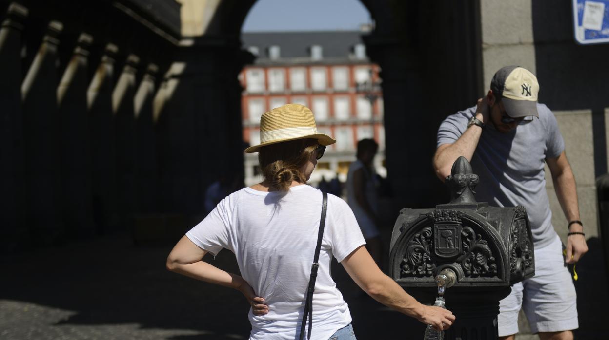 Paseantes aguantan el calor en la Plaza Mayor.