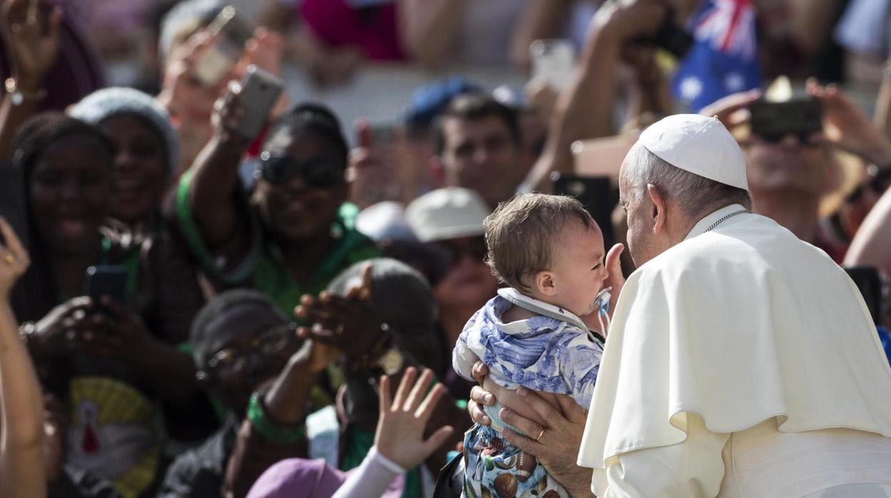 El papa Francisco besa a un niño antes de la audiencia general en la plaza de San Pedro, en el Vaticano