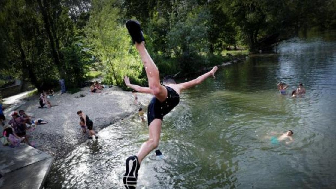 Varios jóvenes combaten el calor este miércoles en el río Arga a su paso por Pamplona