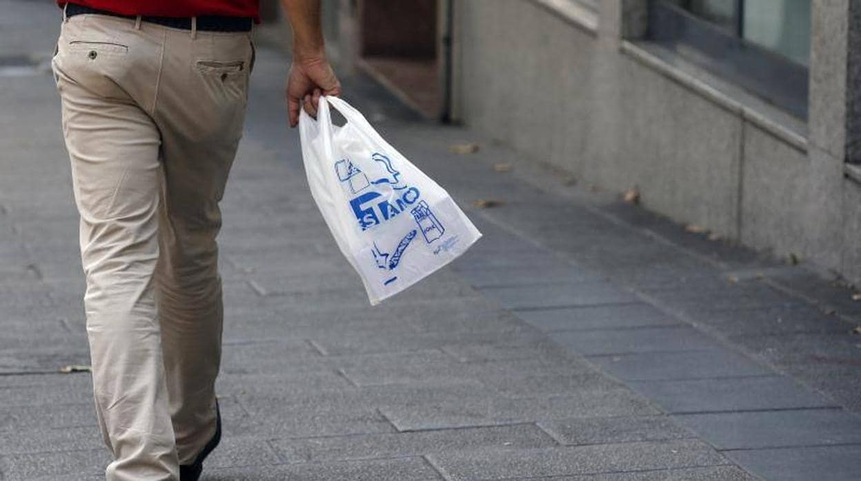 Un hombre camina con una bolsa de plástico