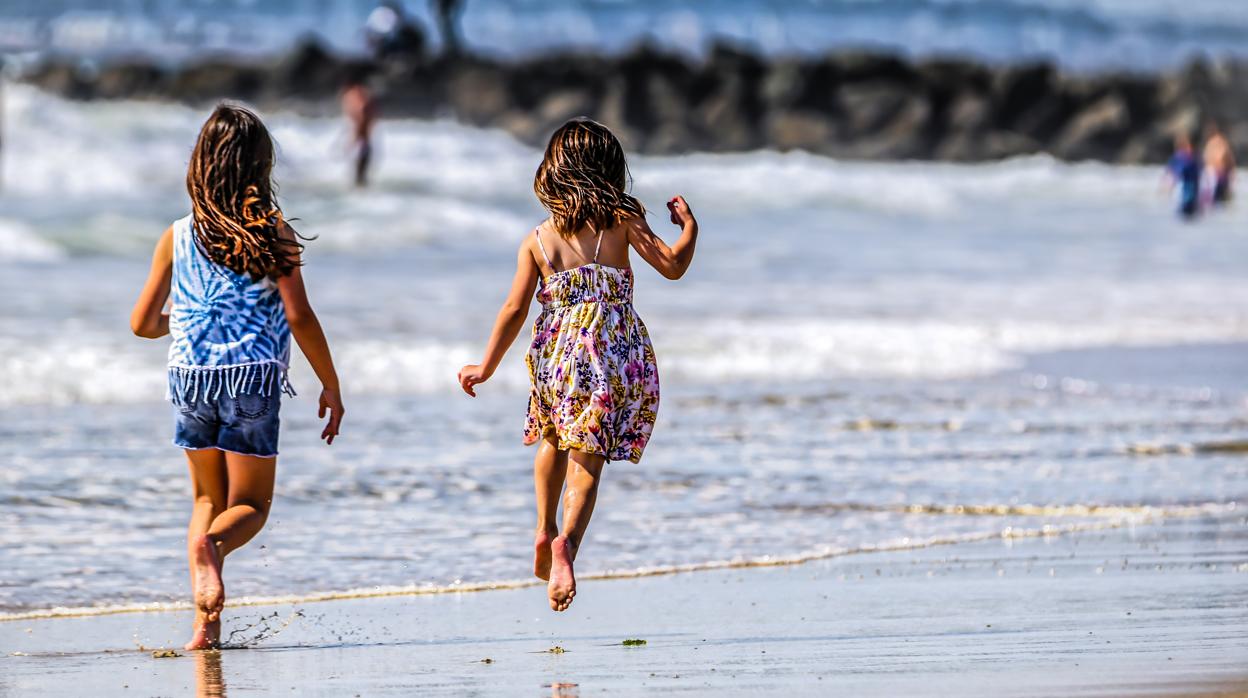 Dos niñas juegan en una playa de California