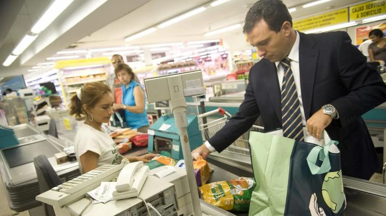 Hombre comprando en un supermercado con una bolsa reutilizable