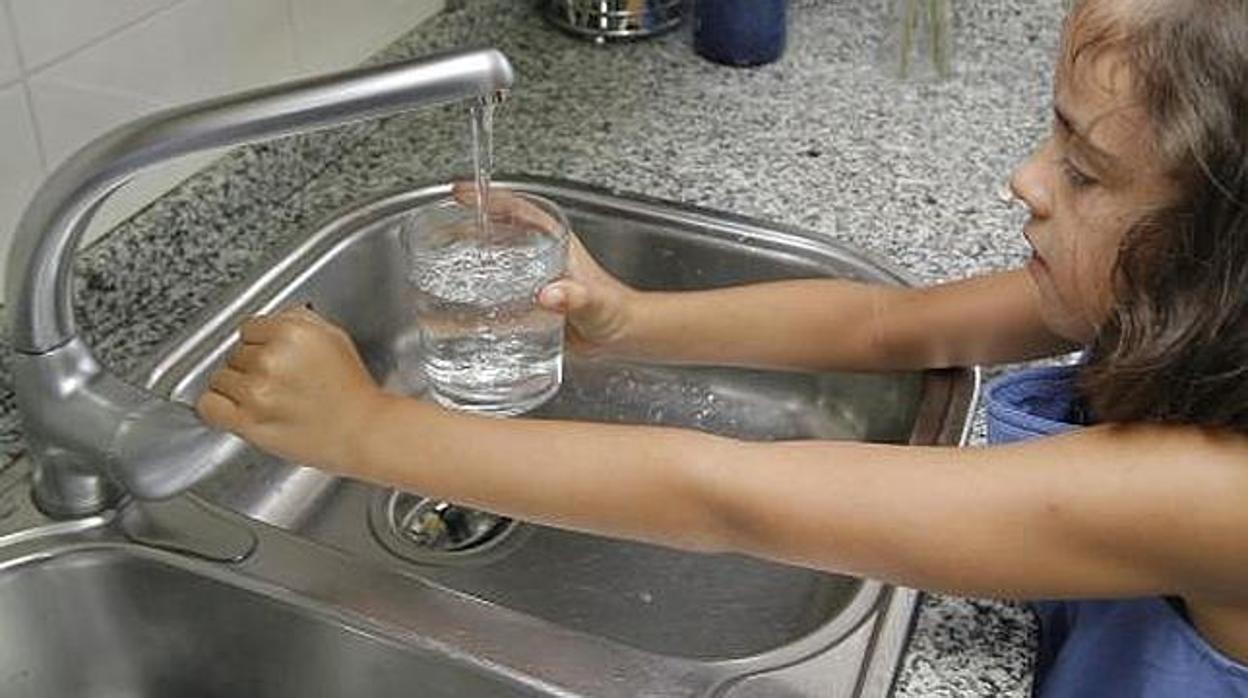 Una niña se sirve un vaso de agua