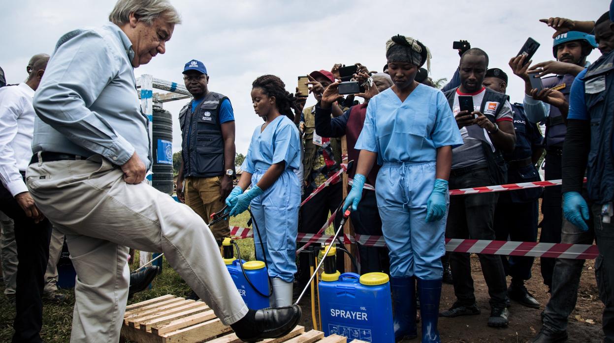 Un equipo desinfecta los zapatos del secretario general de la ONU, Antonio Guterres