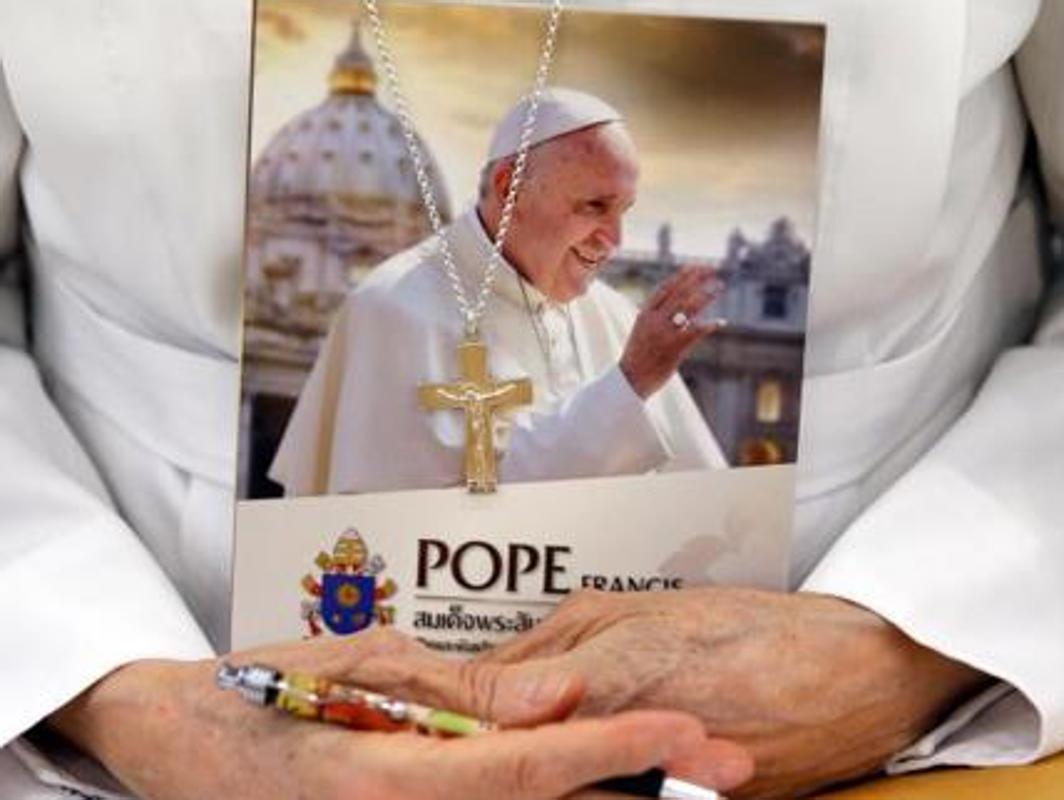 Una religiosa sostiene un libro cuya portada contiene una imagen del Papa Francisco