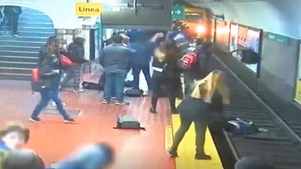 Casi una tragedia que acabó en milagro: La golpearon, cayó a las vías del metro y el tren se detuvo pocos metros antes de atropellarla