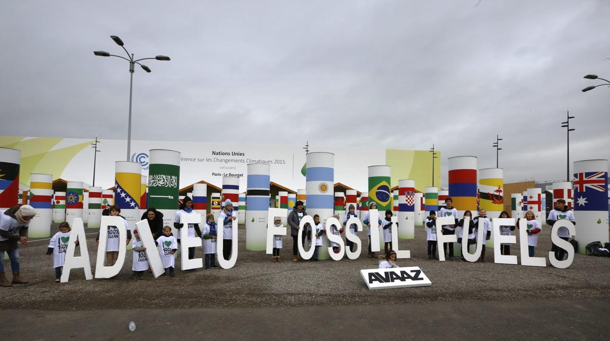 Diciembre de 2015: Niños muestran el mensaje «adieu Fossil FuelsK (Adiós a los hidrocarburos) durante la Conferencia sobre el Cambio Climático en Le Bourget al norte de París (Francia)