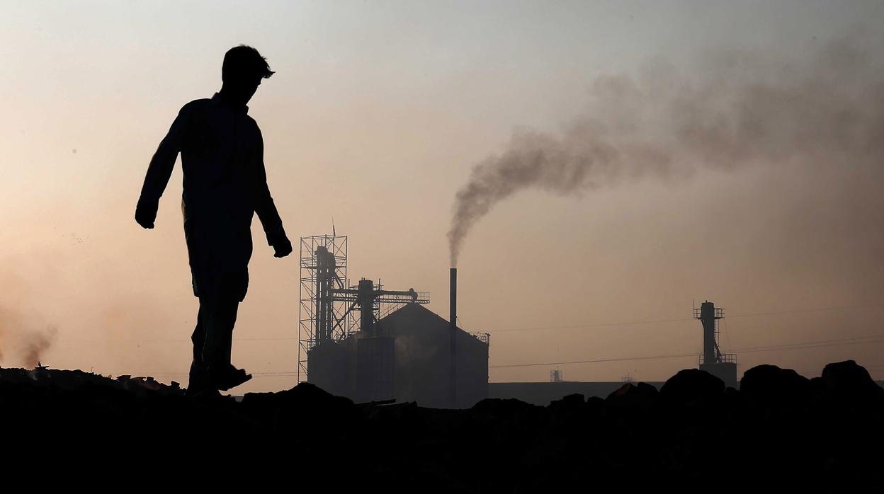 Un hombre camina frente a un horno de ladrillos, en Karachi (Pakistán). Según la ONU, las emisiones de dióxido de carbono han aumentado por primera vez en cuatro años