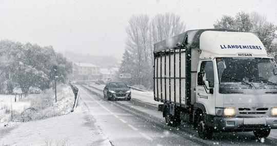 Varios vehículos circulan bajo la nieve en el municipio leonés de Riello, que continúa cubierto ayer, a causa del temporal que afecta al norte de la provincia castellanoleonesa