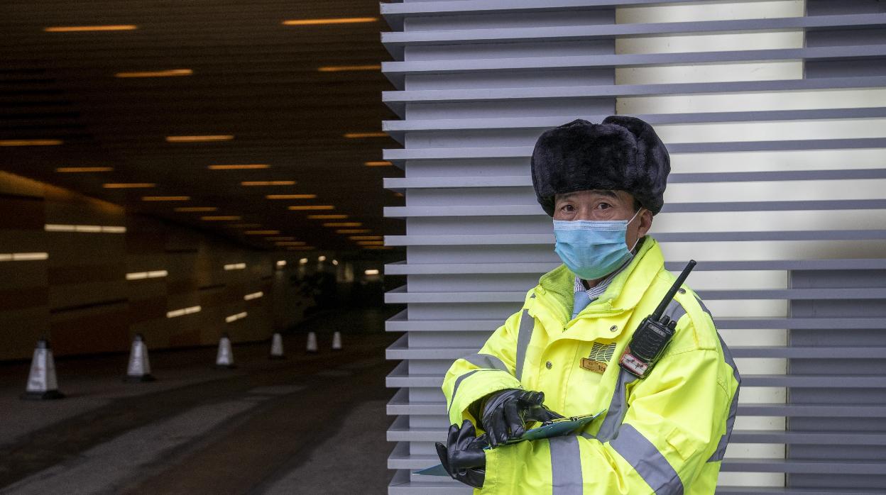 Guarda de seguridad con una mascarilla en Shanghái