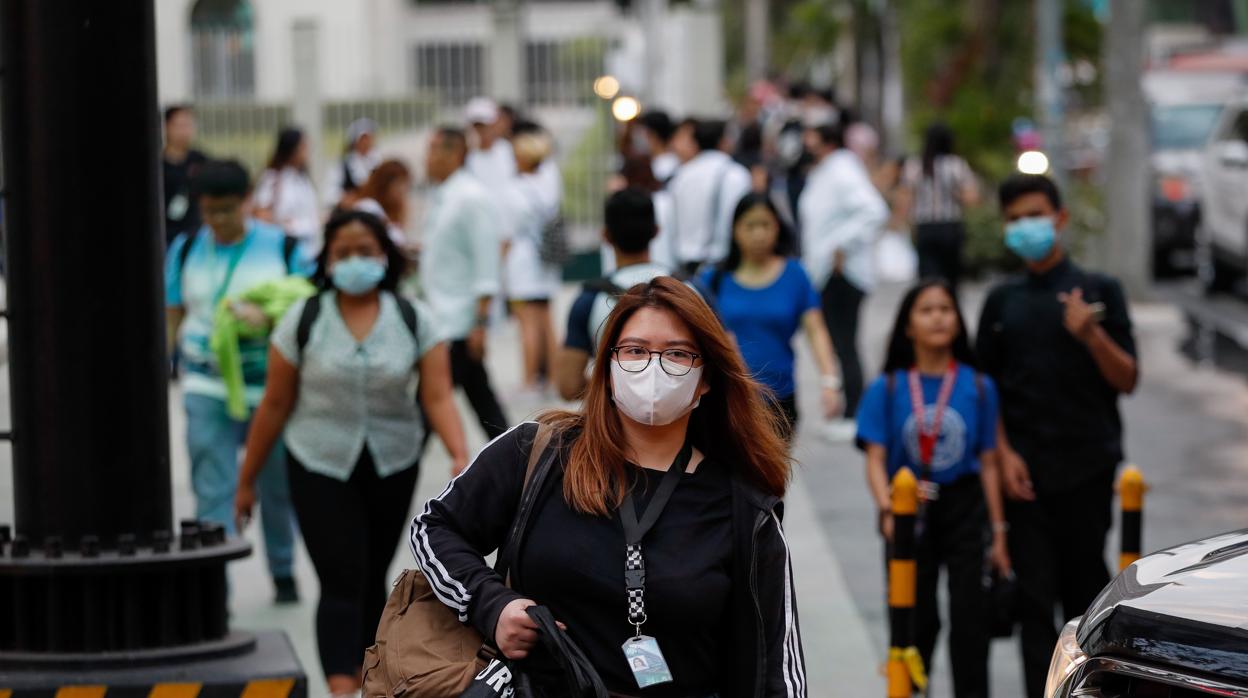 Mujer con mascarilla pasea por Manila