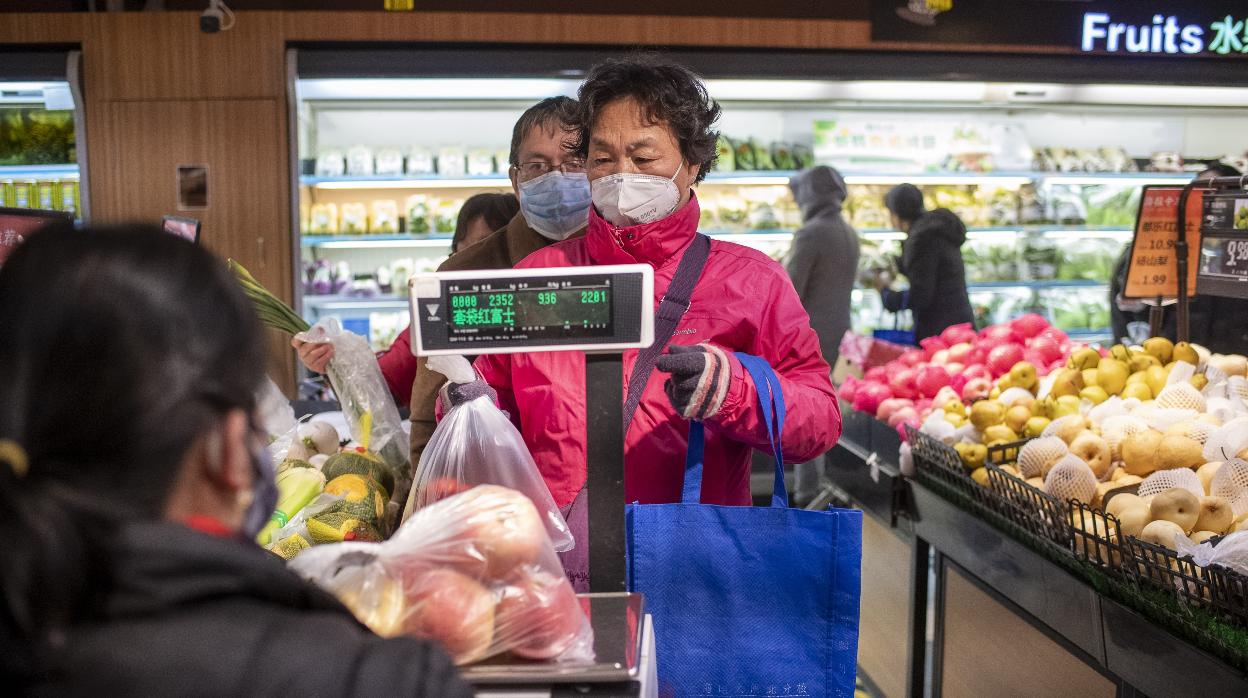 Las personas compran con mascarilla en Shanghai, China