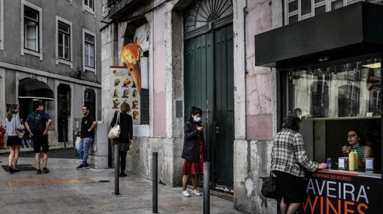 Una mujer con una máscara protectora camina por Lisboa en una imagen tomada el 12 de marzo