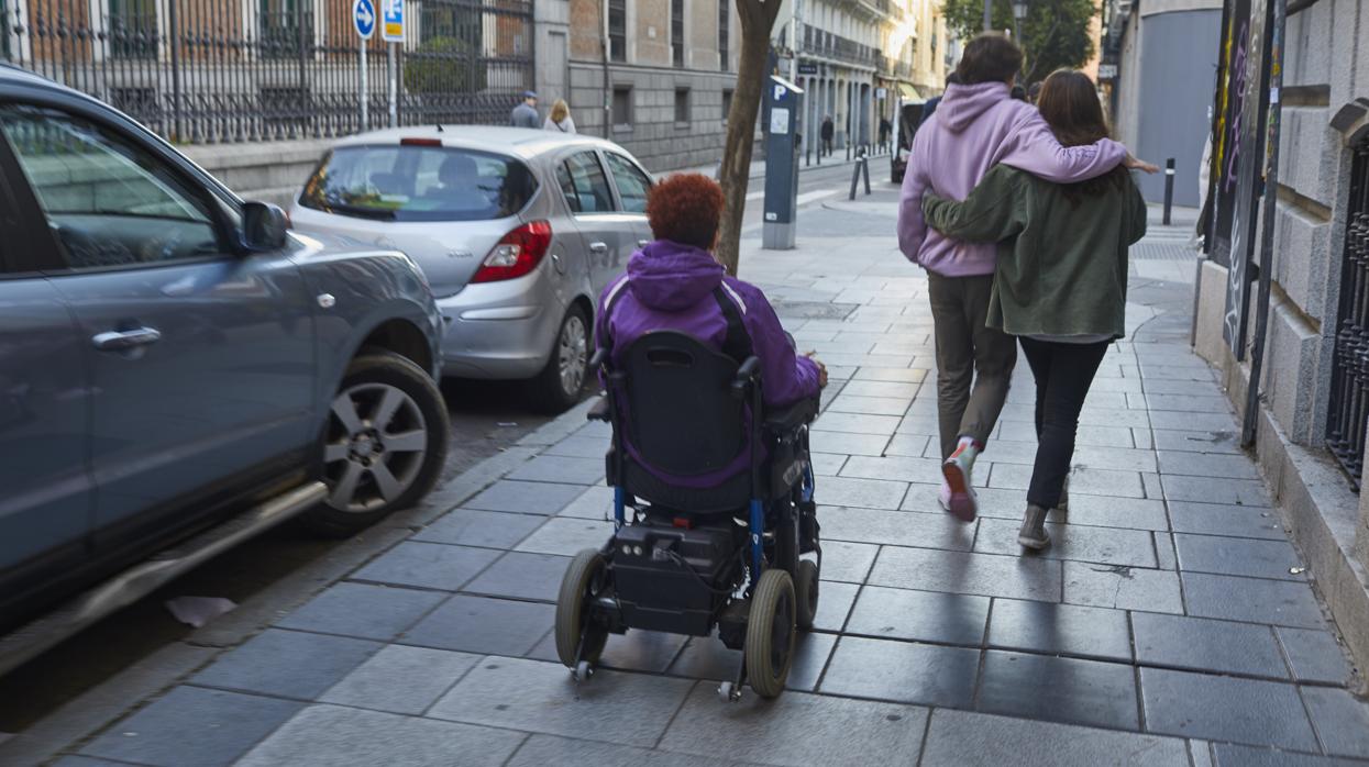 Una mujer en sillas de ruedas, por las calles de Madrid