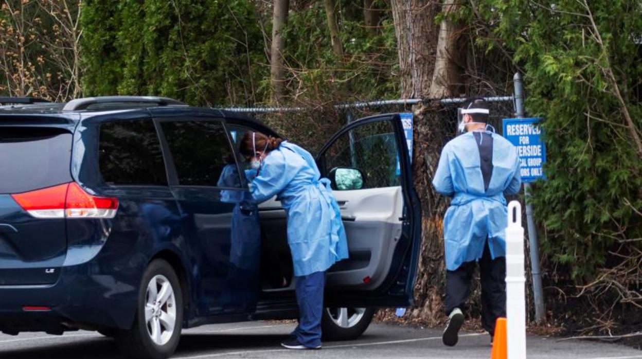 Trabajadores examinan a una persona en un coche en un centro de pruebas en Secaucus, Nueva Jersey