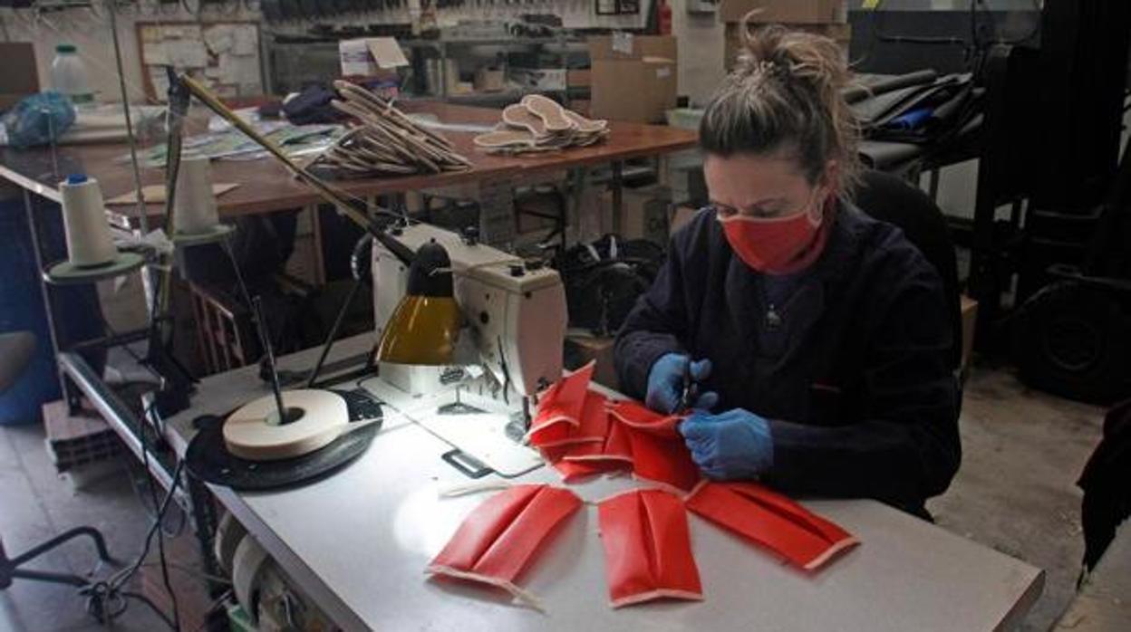 Una mujer confecciona una mascarilla