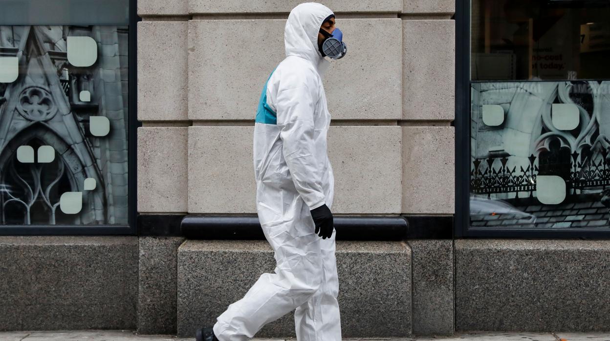 Un hombre camina por las calles de Nueva York con un equipo de protección individual contra el nuevo coronavirus