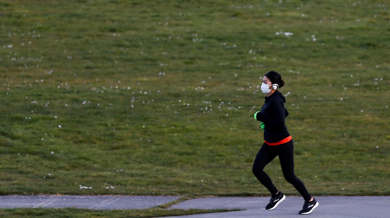 Una mujer corre al aire libre con una mascarilla en Seattle