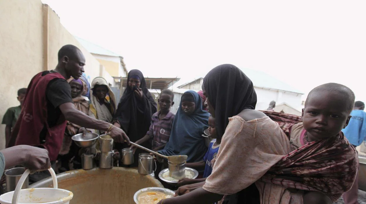 Personas desplazadas somalíes reciben alimentos cocinados de un centro de distribución en el distrito de Hodan